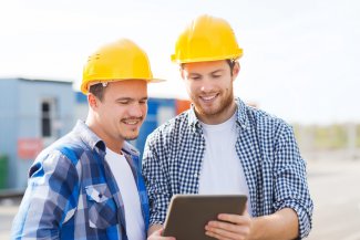 Ouvriers du Bâtiment utilisant une application sur tablette sur un chantier